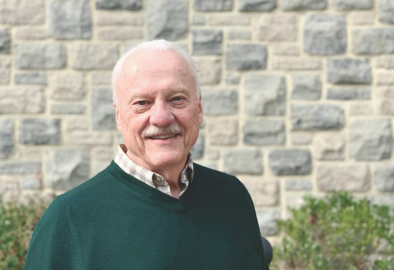 Tom Woteki, founding director of the Academy of Data Science , poses for a photograph in front of a building with Hokie stone